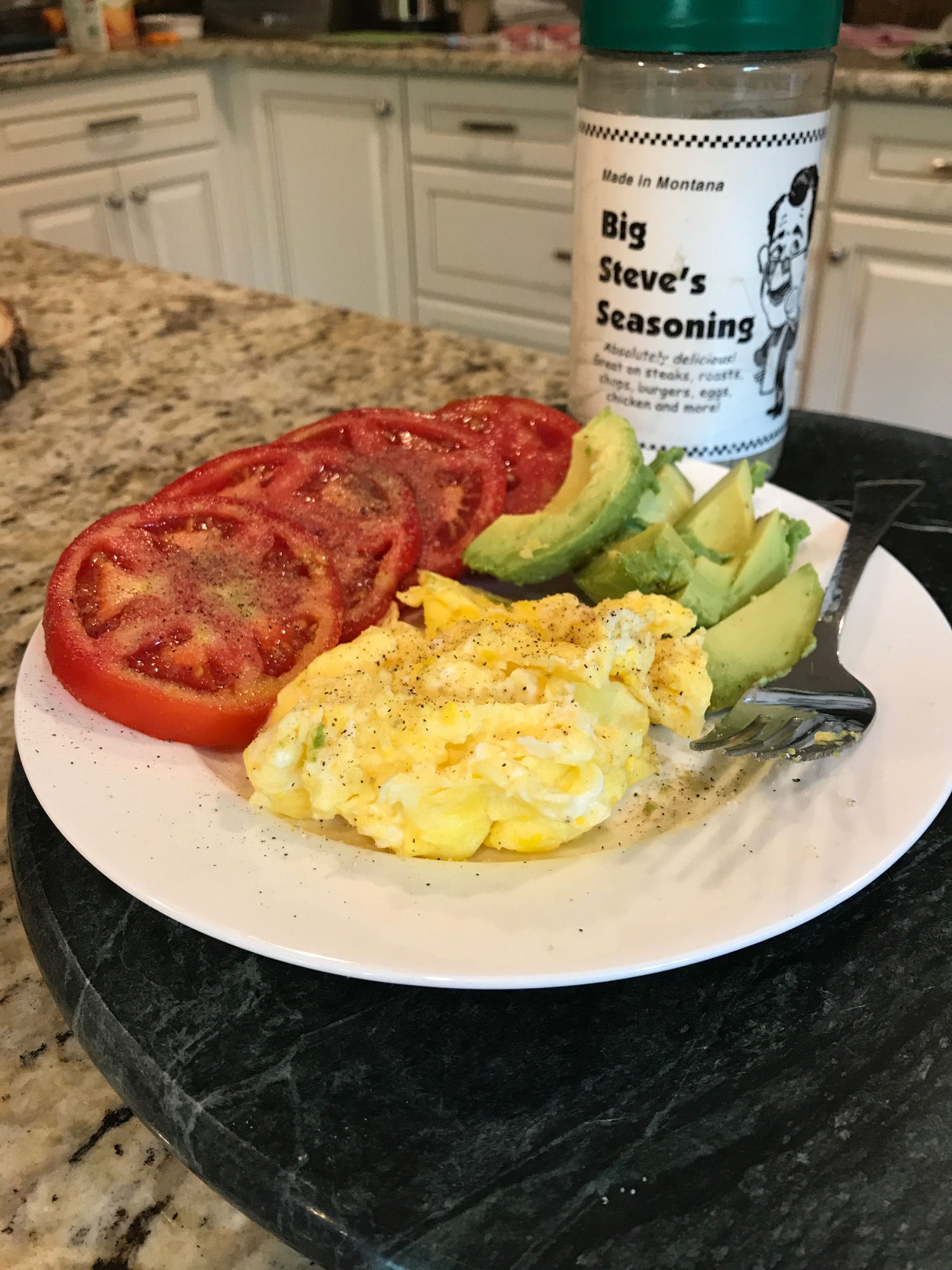 Scrambled eggs, avocado and tomato with seasoning